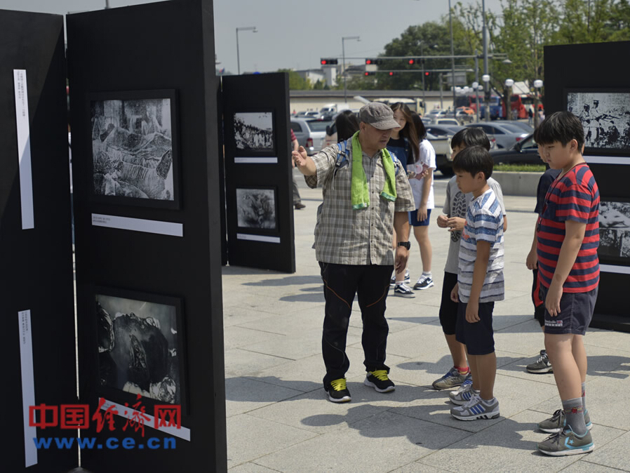 百余張抗日戰爭歷史圖片在首爾展出 韓國老人向孫輩講述當年日軍罪行