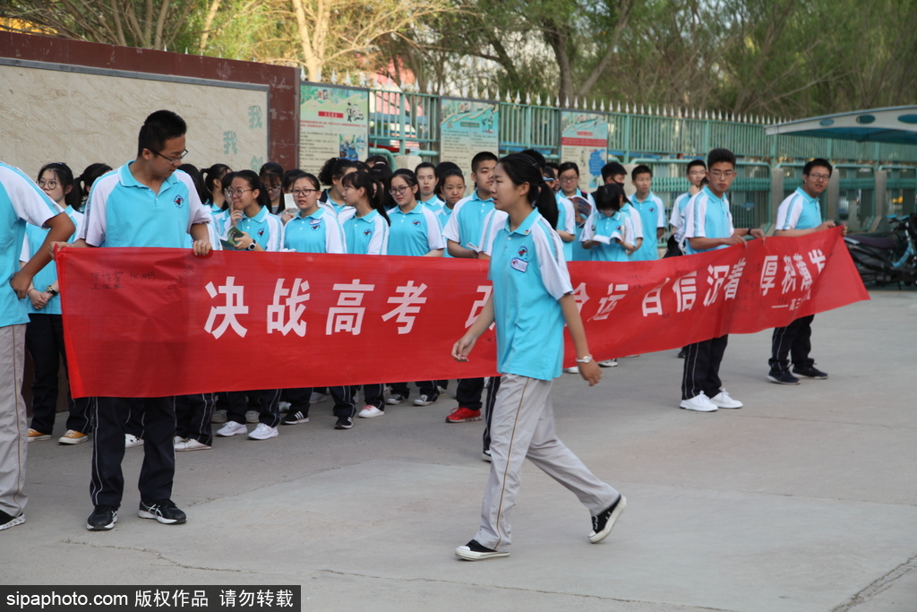 新疆哈密：高考第一日 低年級學(xué)生家長送考沿路壯行
