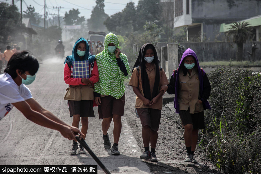 錫納朋火山噴發后 火山灰漫山遍野村民戴口罩清掃