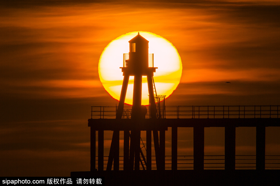 英國惠特比碼頭日出風光 燈塔影影綽綽景色美