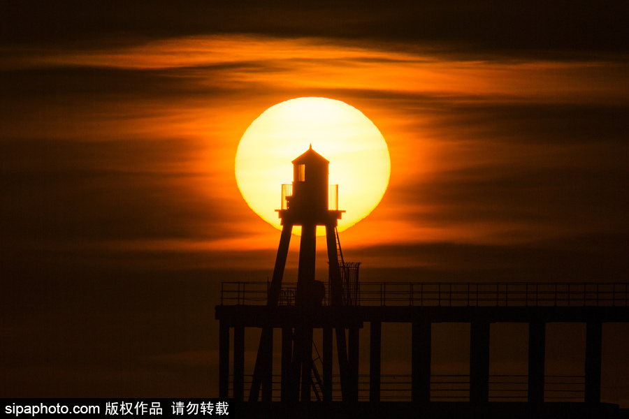 英國惠特比碼頭日出風光 燈塔影影綽綽景色美