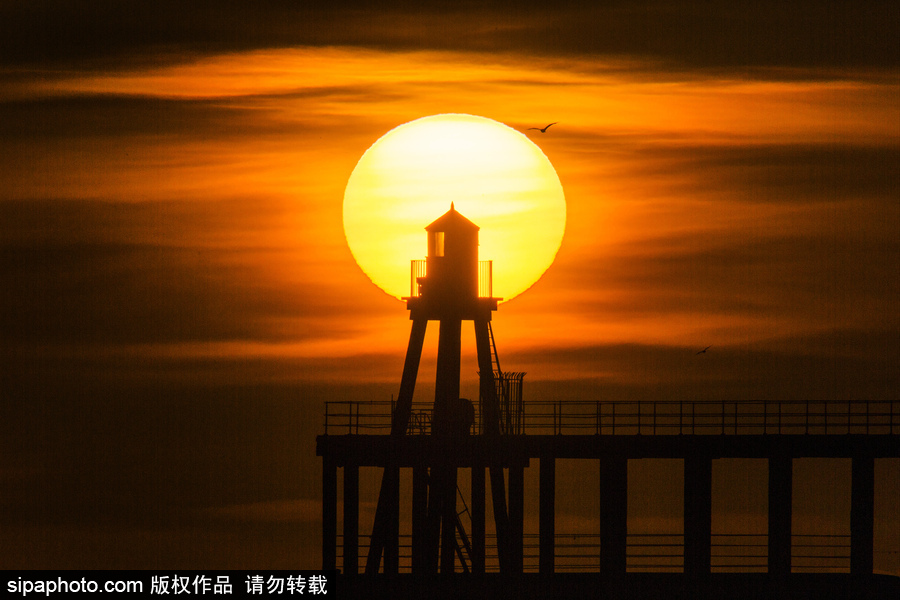 英國惠特比碼頭日出風光 燈塔影影綽綽景色美